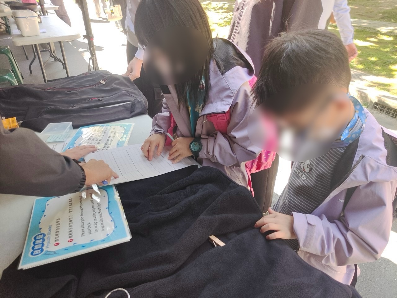 肢體障礙，畫面中為兩位闖關者試著單手將拉鍊拉上